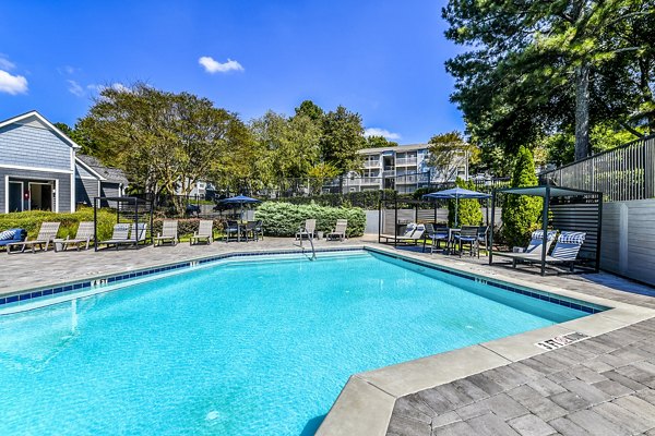 Relaxing poolside area with lounge chairs at Avana Woods Apartments, ideal for residents seeking a tranquil retreat
