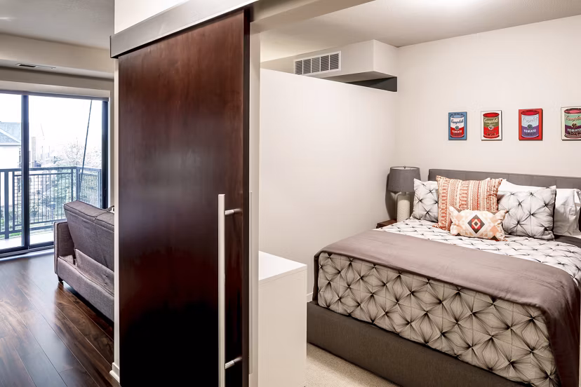 Modern bedroom with sleek furnishings at The Paxon Apartments, offering luxury living in a desirable urban location