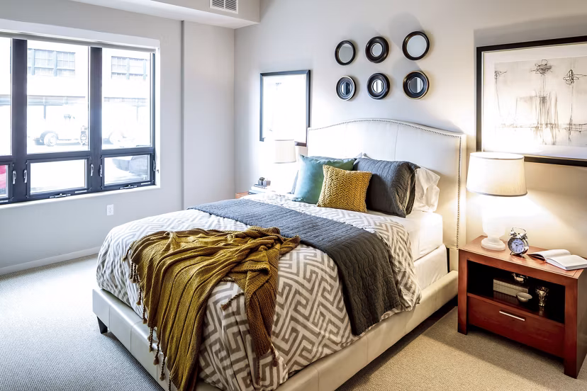 Cozy bedroom featuring modern decor and plush bedding at The Paxon Apartments, a luxury living space by Greystar