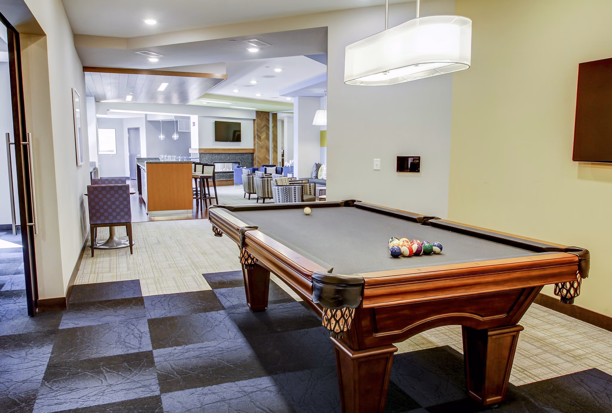 Game room with billiards and lounge seating at The Paxon Apartments