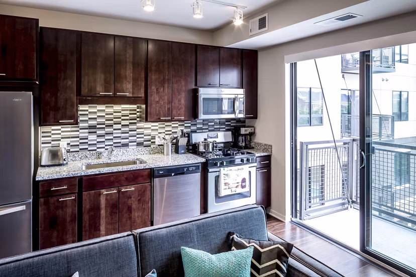 Modern kitchen with stainless steel appliances at The Paxon Apartments