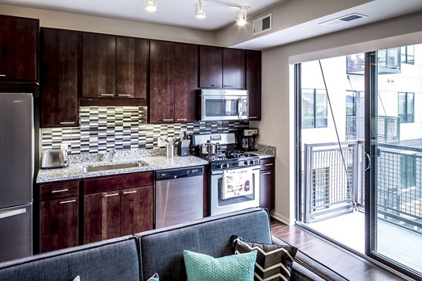 Modern kitchen with stainless steel appliances at The Paxon Apartments