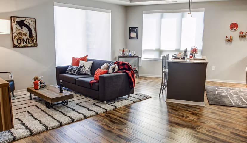 Spacious living room with modern decor and ample natural light in The Paxon Apartments, Greystar luxury apartment community