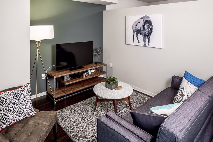 Living room with stylish decor at The Paxon Apartments featuring cozy seating and modern amenities