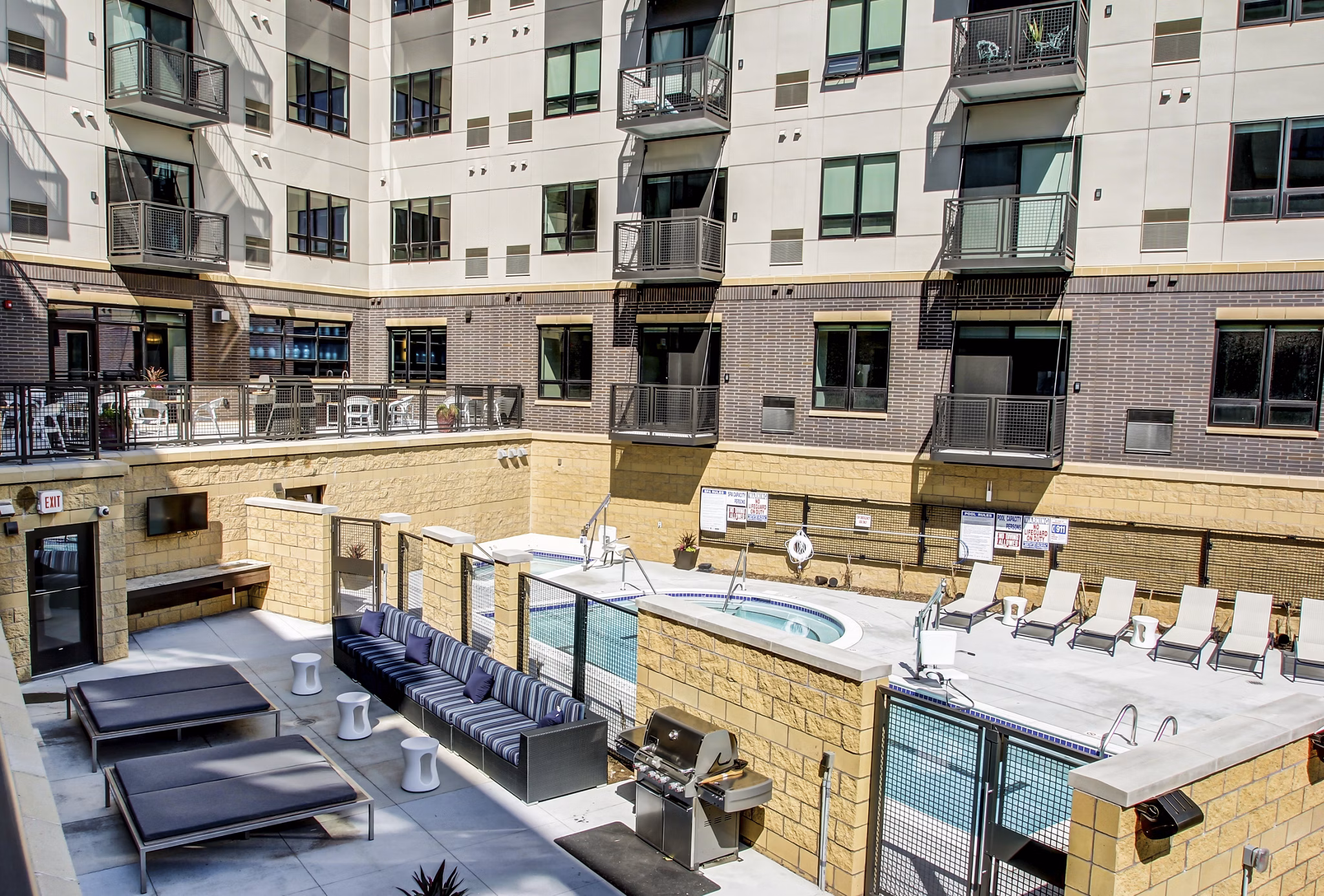 Outdoor swimming pool with lounging area at The Paxon Apartments, offering a luxurious retreat in a modern residential setting