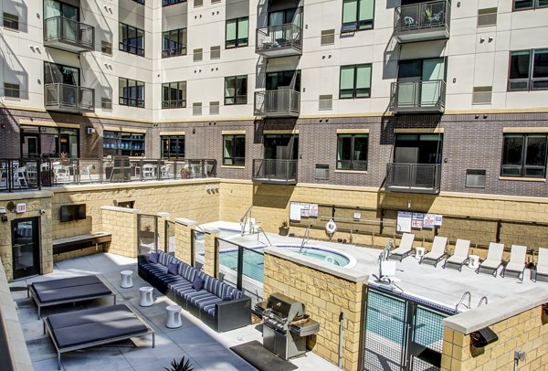 Outdoor swimming pool with lounging area at The Paxon Apartments, offering a luxurious retreat in a modern residential setting