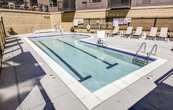 Resort-style pool area at The Paxon Apartments with luxurious lounge seating and modern landscaping
