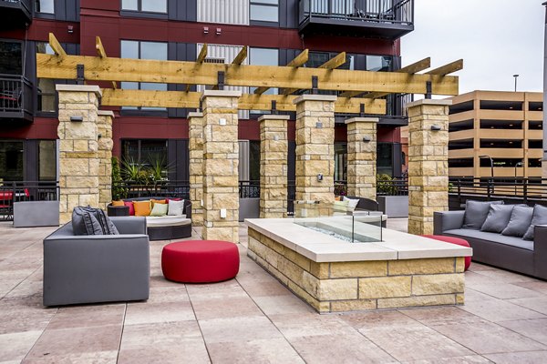 Fire pit surrounded by modern seating at Velo Apartments patio offering luxury outdoor living spaces