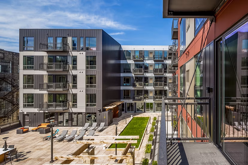 Scenic patio with seating area and lush greenery at Velo Apartments