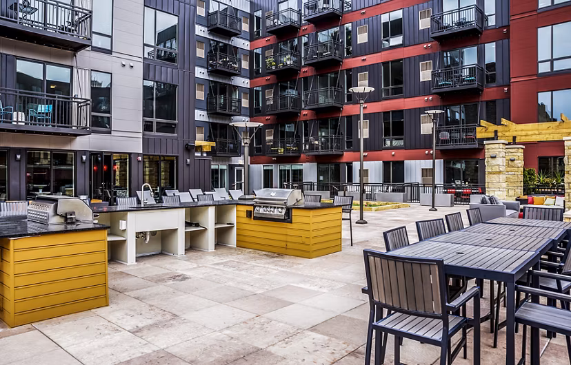Outdoor grill area with modern seating at Velo Apartments, sustainable luxury living in urban location