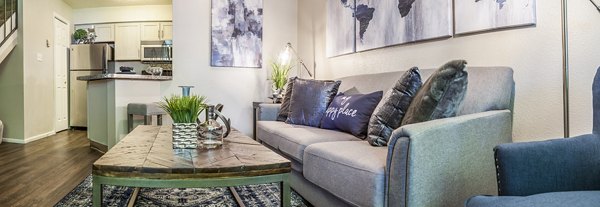 Open-concept living room with modern decor and large windows at Spring Park Apartments