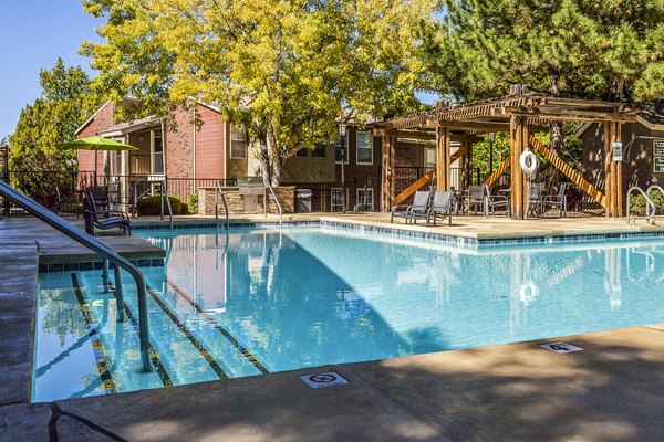 Pool area with sun loungers at Spring Park Apartments offers a relaxing retreat in a luxury residential community