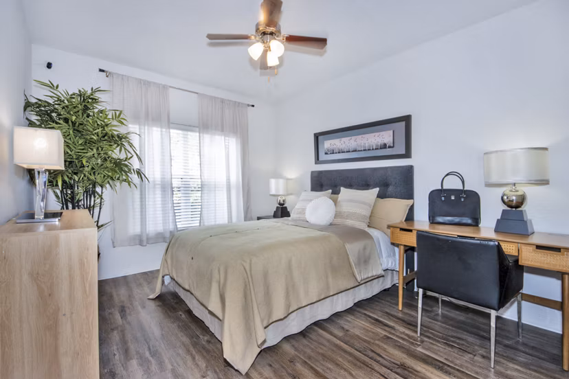 Bedroom and home office with stylish furnishings and ample natural light at Mira Flores Apartments