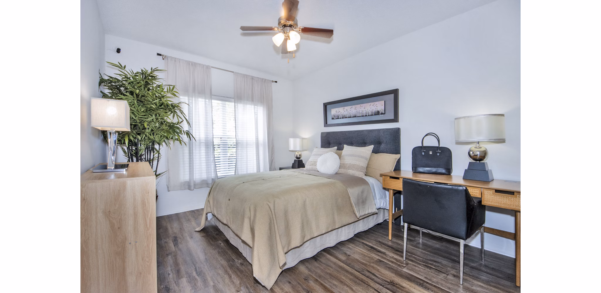 Bedroom and home office with stylish furnishings and ample natural light at Mira Flores Apartments