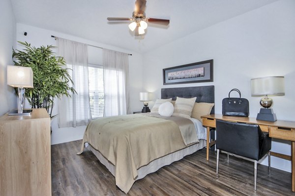 Bedroom and home office with stylish furnishings and ample natural light at Mira Flores Apartments