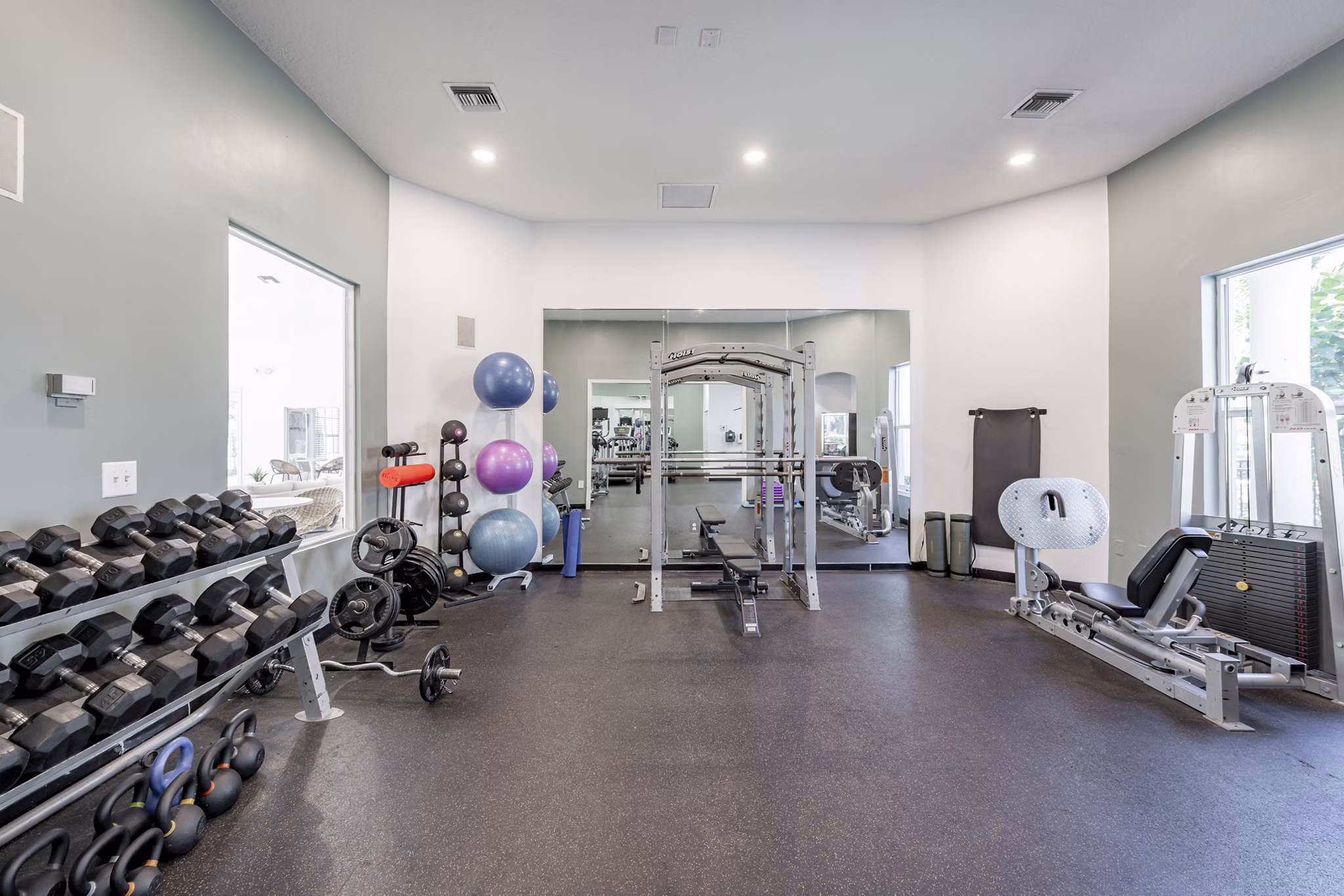 Fully equipped fitness center at Mira Flores Apartments featuring modern exercise machines and spacious workout areas