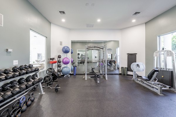Fully equipped fitness center at Mira Flores Apartments featuring modern exercise machines and spacious workout areas