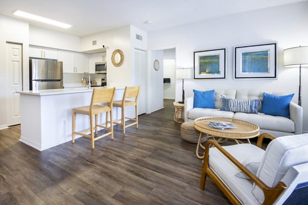 Spacious living room with sleek furniture and natural lighting in Mira Flores Apartments, luxury Greystar property