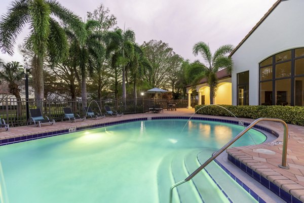 Infinity-edge pool at Mira Flores Apartments with lush garden views