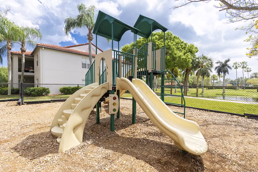 Mira Flores Apartments: Modern playground with slides and climbing structures, offering family-friendly amenities