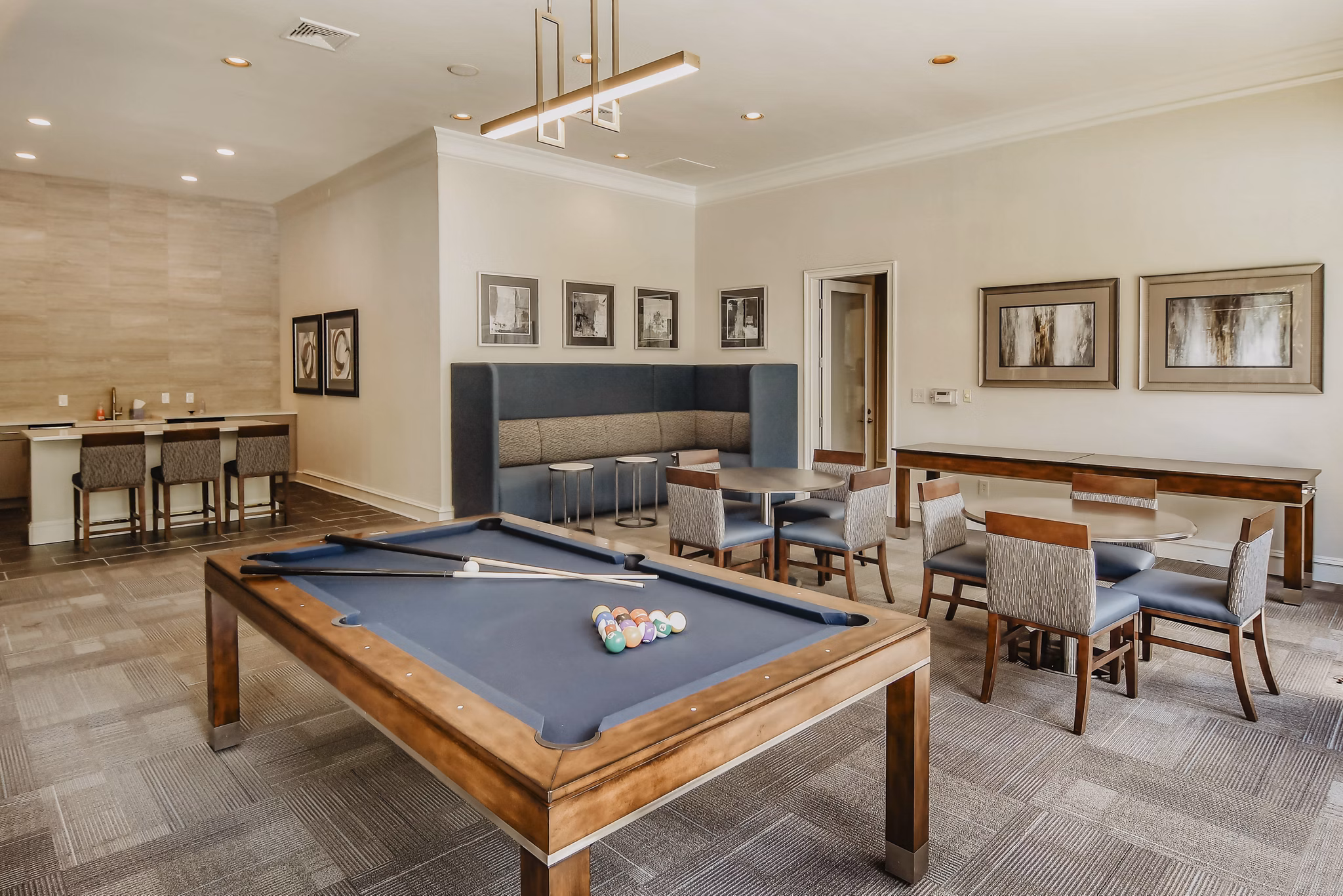 Modern clubhouse game room with pool tables and lounge seating at Finley at Fairfax Corner luxury apartments