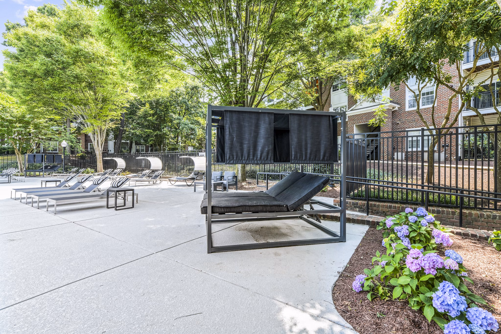 Serene pool patio surrounded by greenery at Finley at Fairfax Corner Apartments, offering a luxury outdoor escape for residents