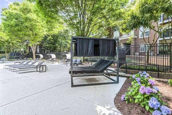 Serene pool patio surrounded by greenery at Finley at Fairfax Corner Apartments, offering a luxury outdoor escape for residents