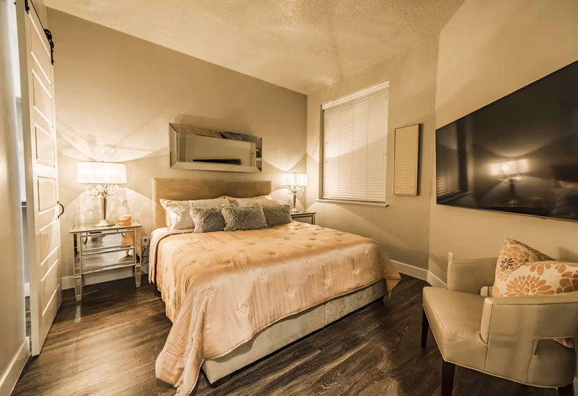 Bedroom with modern furnishings and large windows at Hardware Village Apartments