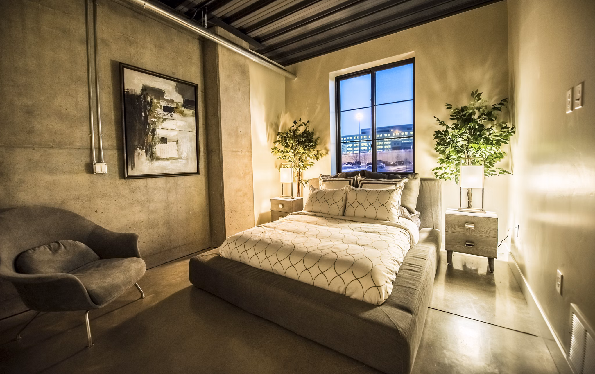 Spacious bedroom with modern decor in Hardware Village Apartments, featuring ample natural light and stylish furnishings