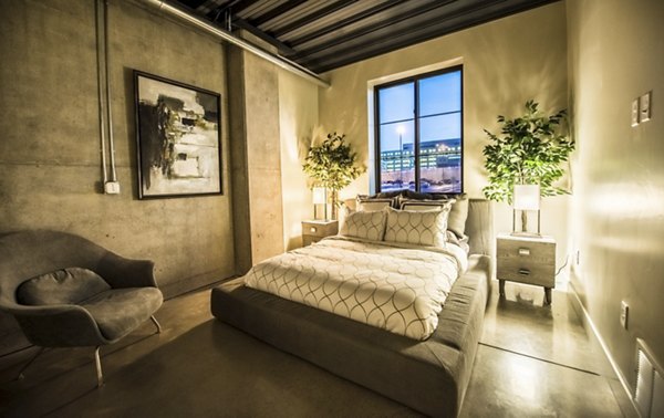 Spacious bedroom with modern decor in Hardware Village Apartments, featuring ample natural light and stylish furnishings
