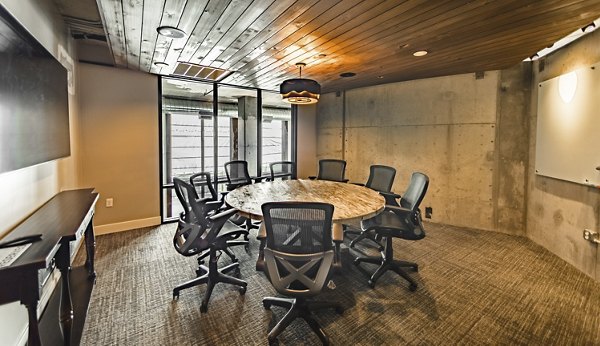 Meeting room with modern conference table and AV equipment at Hardware Village Apartments for business and community events