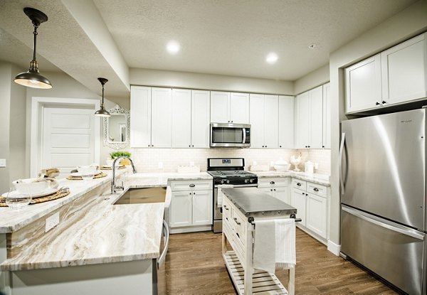 Modern kitchen with sleek countertops and stainless steel appliances at Hardware Village Apartments