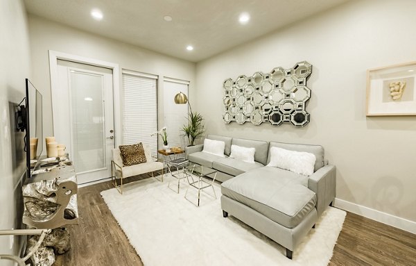 Living room with modern furnishings and large windows in Hardware Village Apartments, Salt Lake City