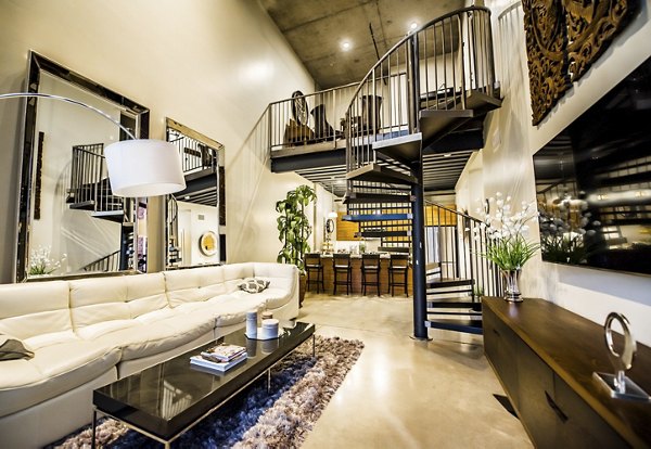 Chic living room with modern decor at Hardware Village Apartments, featuring sleek furnishings and ample natural light