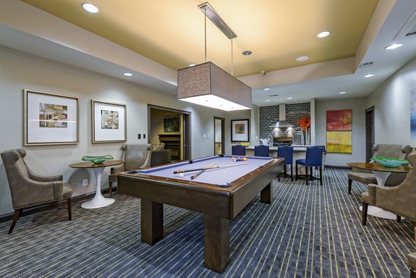 Game room featuring pool tables and large screen TVs at The Prato at Midtown Apartments, offering modern entertainment spaces for residents