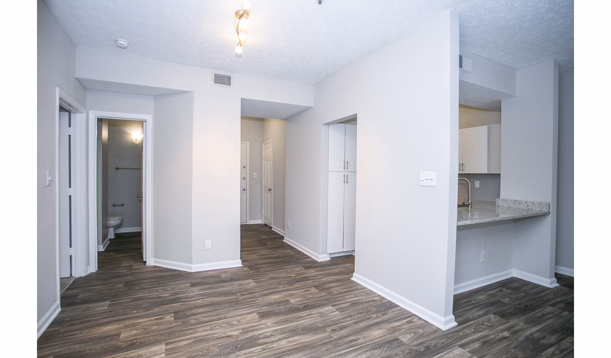 Dining room with elegant chandelier and modern furnishings at The Prato at Midtown Apartments
