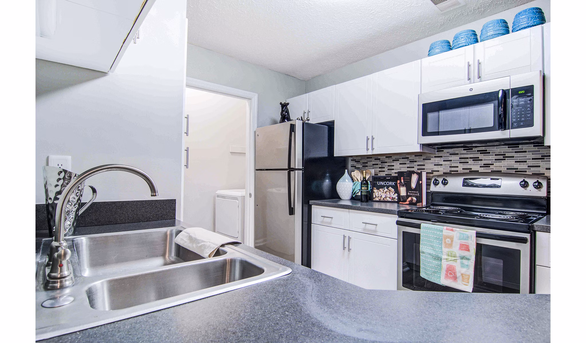 Kitchen with stainless steel appliances and granite countertops at The Prato at Midtown Apartments