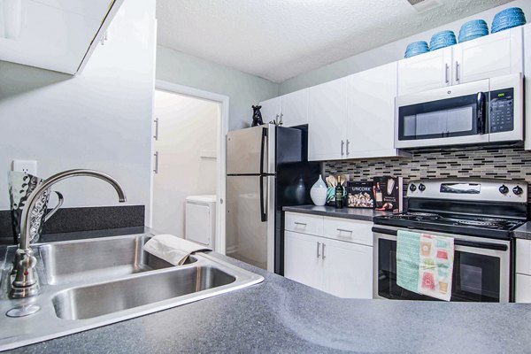 Kitchen with stainless steel appliances and granite countertops at The Prato at Midtown Apartments