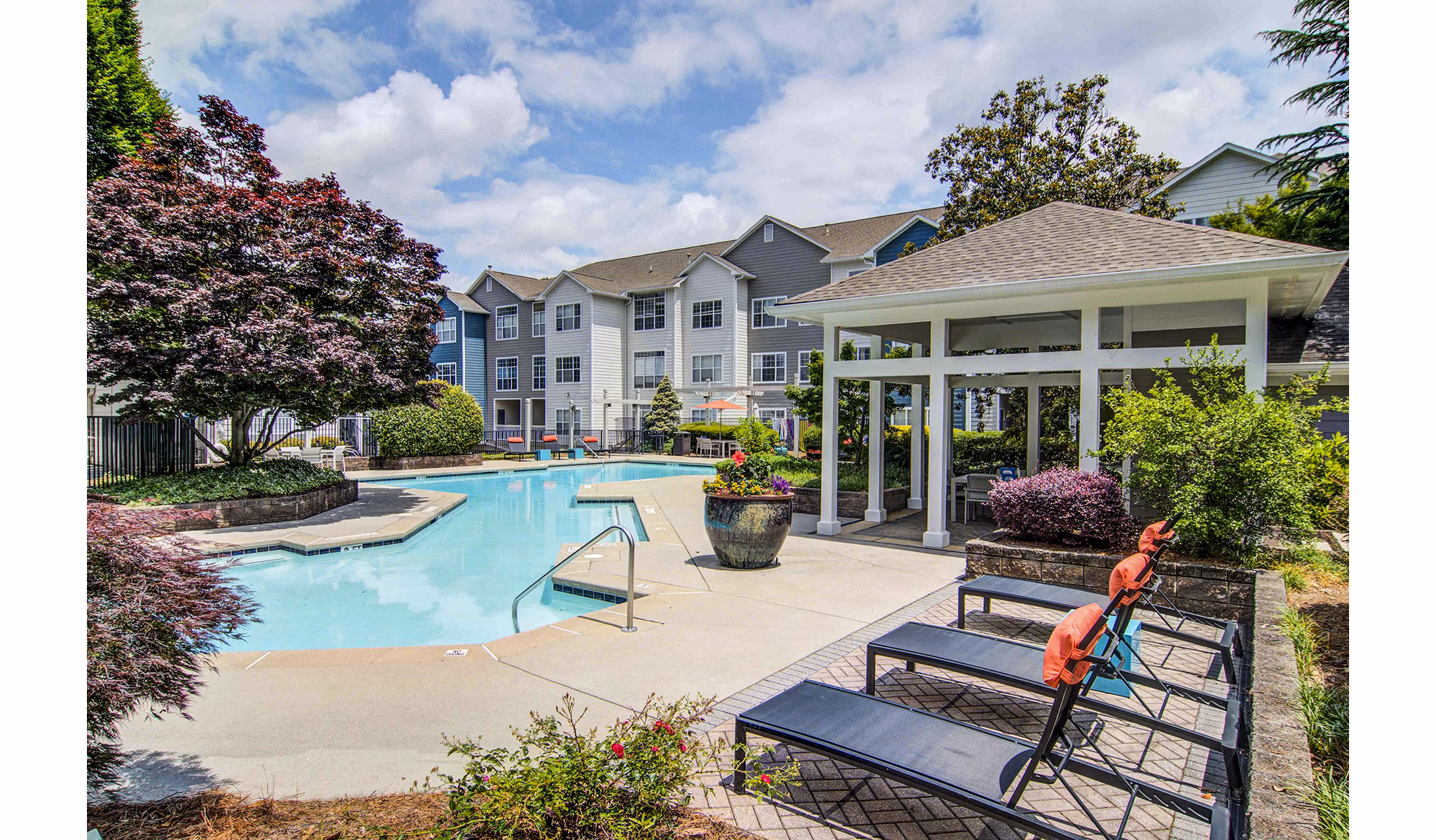 Relaxing pool area with sun loungers at The Prato at Midtown Apartments