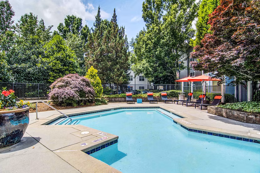 Luxurious pool with sun loungers at The Prato at Midtown Apartments