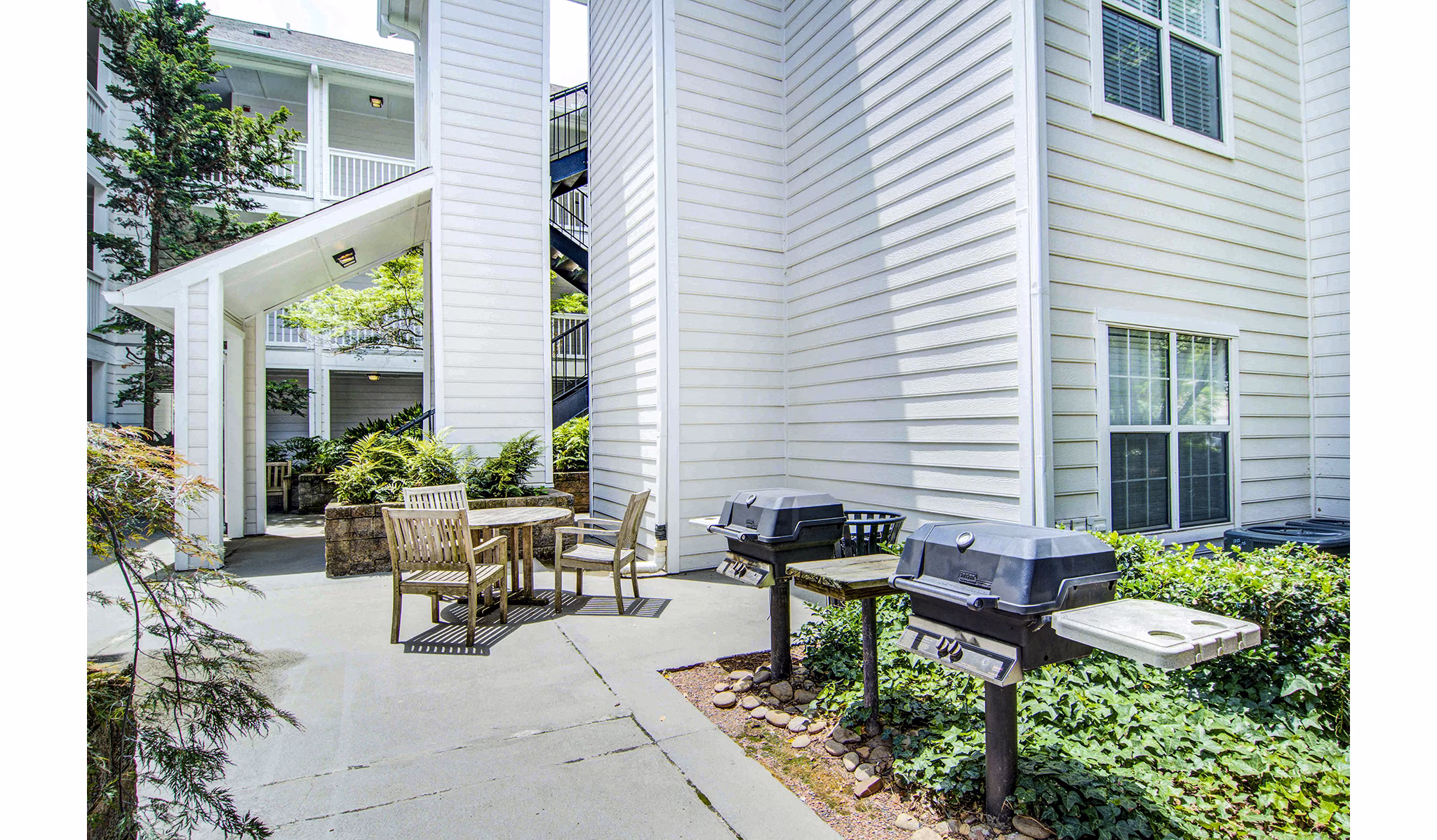 Outdoor grill area with modern seating at The Prato at Midtown Apartments