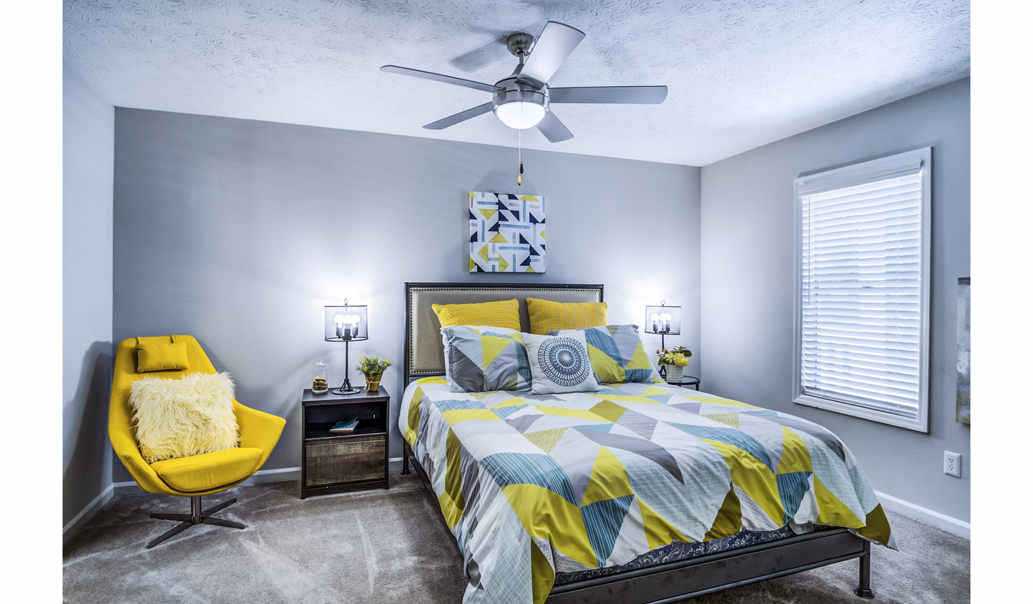Cozy bedroom with modern decor in Junction at Vinings Apartments featuring natural light and plush bedding