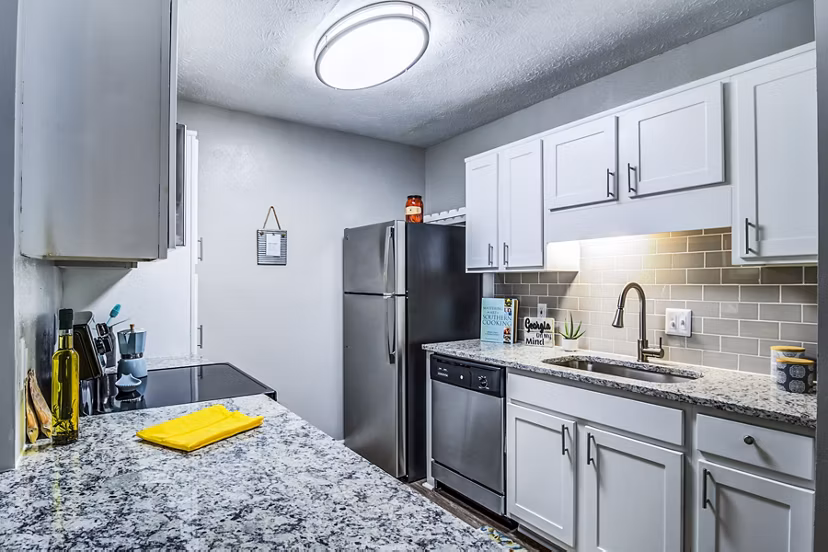 Modern kitchen with granite countertops and stainless steel appliances at Junction at Vinings Apartments