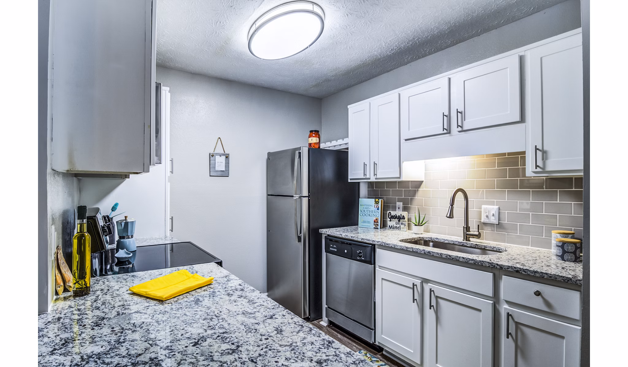 Modern kitchen with granite countertops and stainless steel appliances at Junction at Vinings Apartments