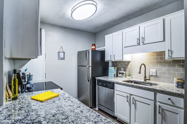 Modern kitchen with granite countertops and stainless steel appliances at Junction at Vinings Apartments