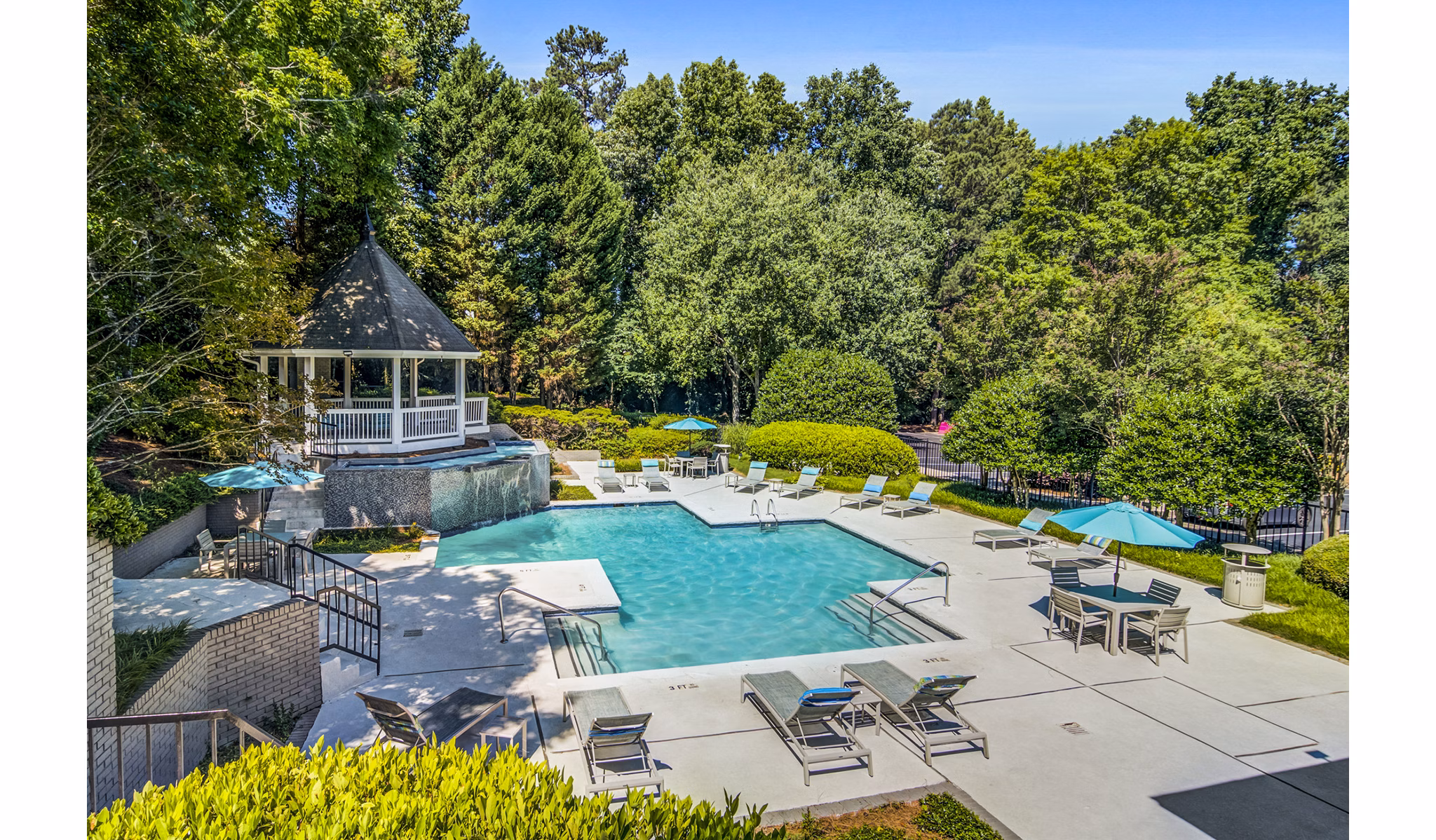 Poolside lounging area at Junction at Vinings Apartments with luxury seating and landscaping