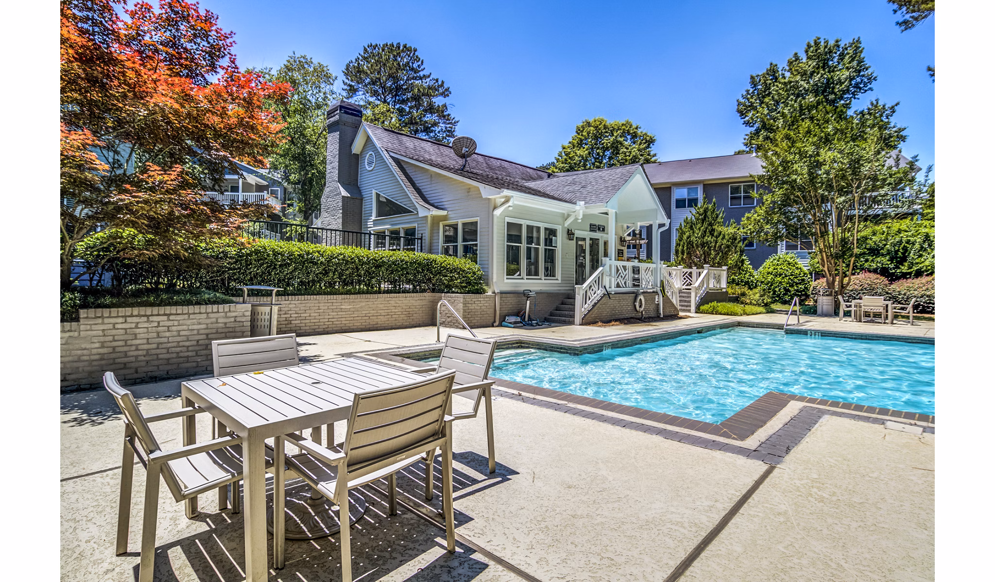 Resort-style pool at Junction at Vinings Apartments featuring sun loungers and landscaped surroundings
