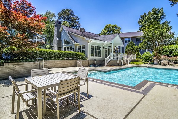 Resort-style pool at Junction at Vinings Apartments featuring sun loungers and landscaped surroundings