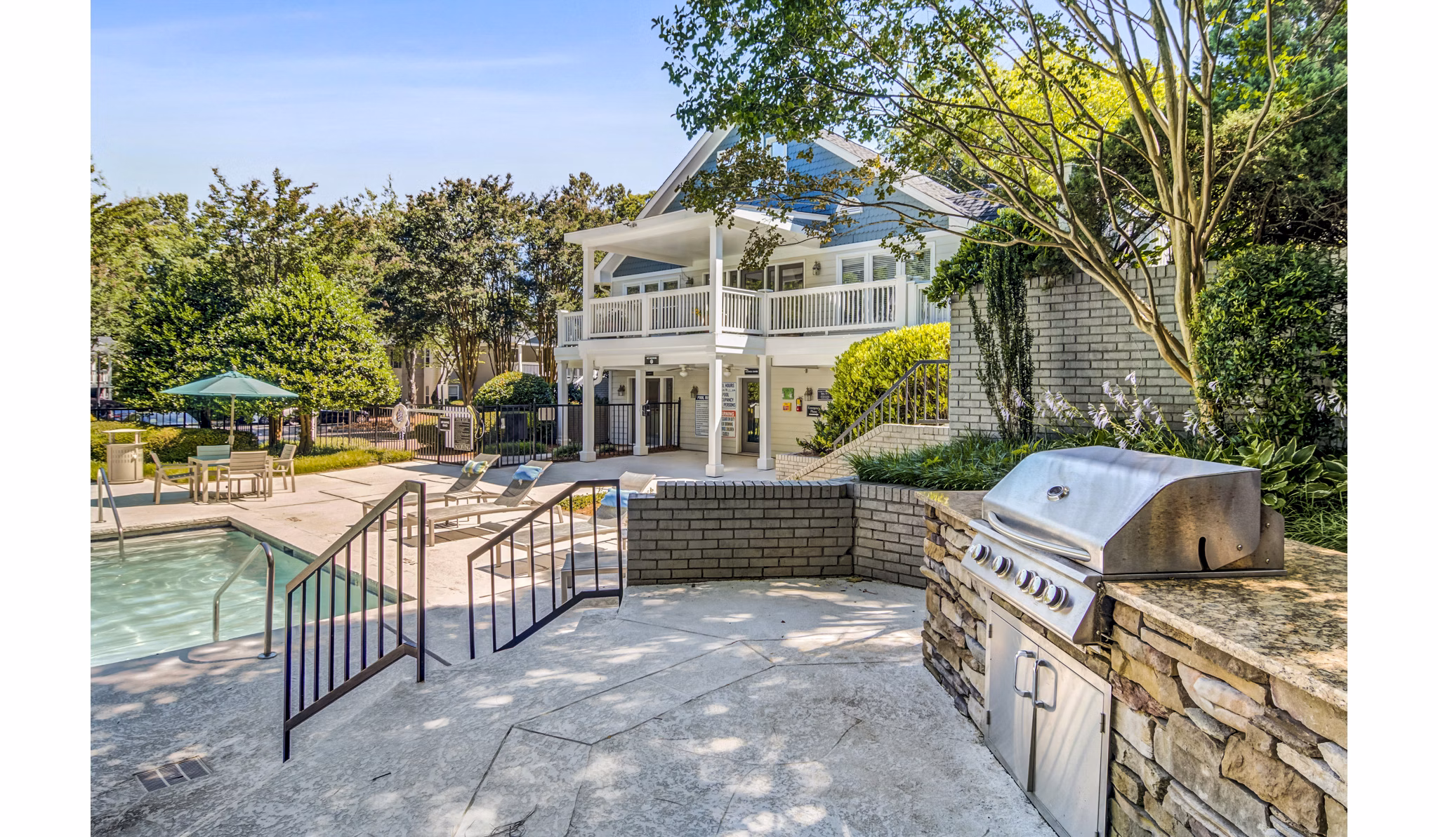 Outdoor pool and grill area with seating at Junction at Vinings Apartments in a luxurious setting