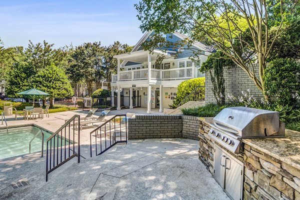 Outdoor pool and grill area with seating at Junction at Vinings Apartments in a luxurious setting